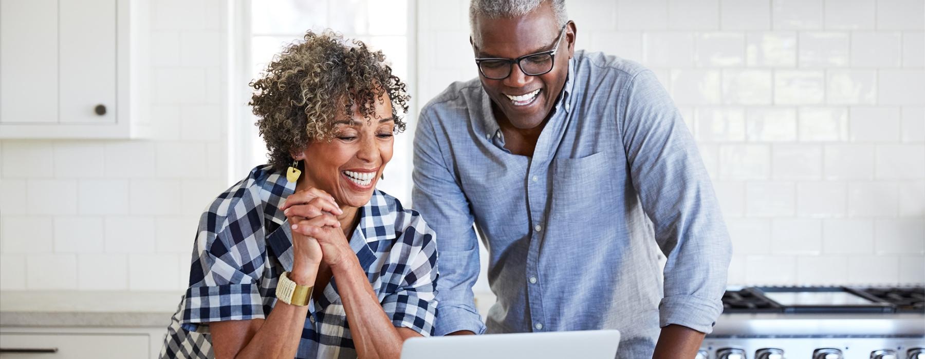 a man and a woman looking at a laptop